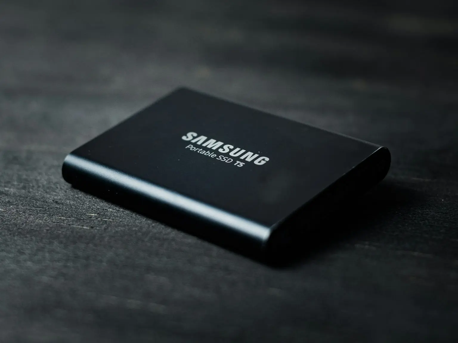 black power bank on black wooden table